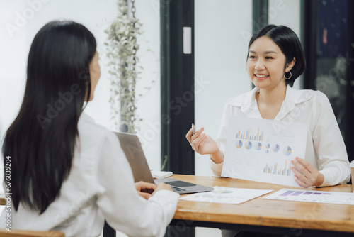 Group of confident business people point to graphs and charts to analyze market data, balance sheet, account, net profit to plan new sales strategies to increase production capacity.