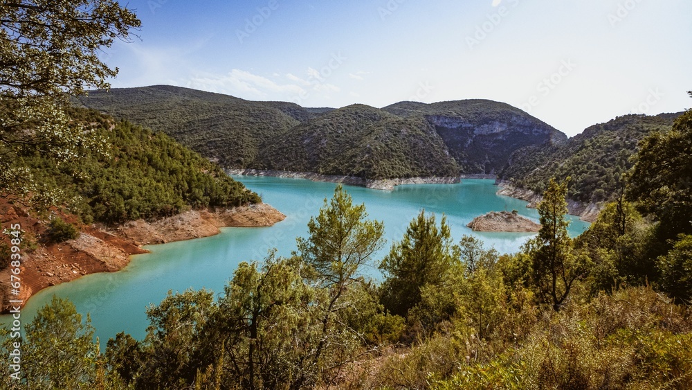 Aerial view of the Noguera Ribagorzana river with a cloudy blue sky in the background, Spain