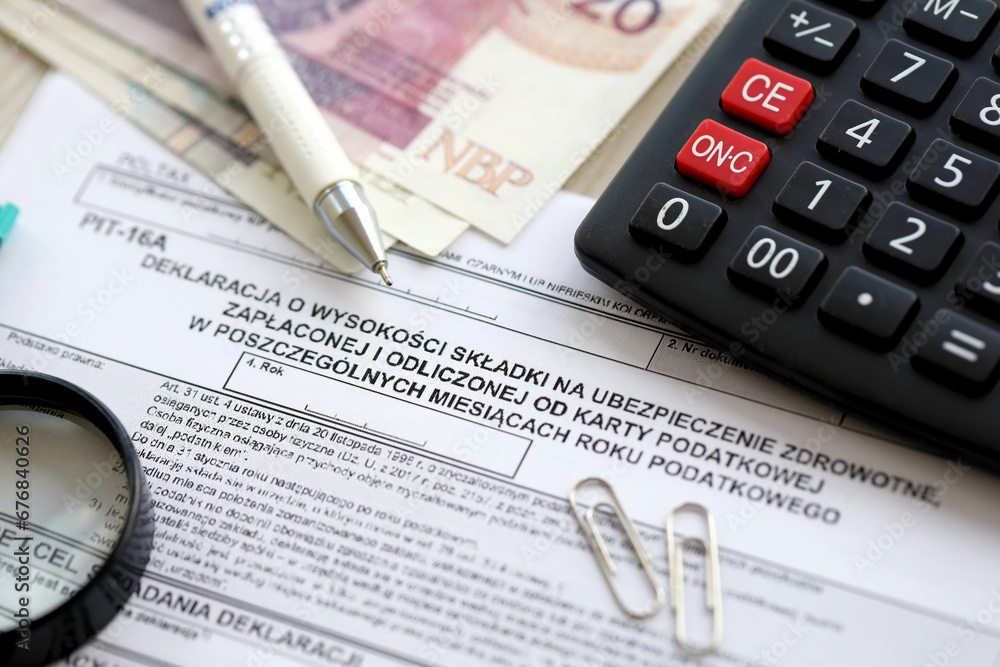 Declaration of amount of health insurance contributions paid and deducted from tax card in individual months of tax year, PIT-16A form on accountant table with pen and polish zloty money bills Declaration of amount of health insurance contributions paid and deducted from tax card in individual months of tax year, PIT-16A form on accountant table with pen and polish zloty money bills