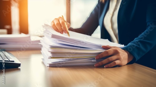 Businesswoman hands working in Stacks of paper files for searching information on work desk in office, business report papers. create using a generative ai tool  photo
