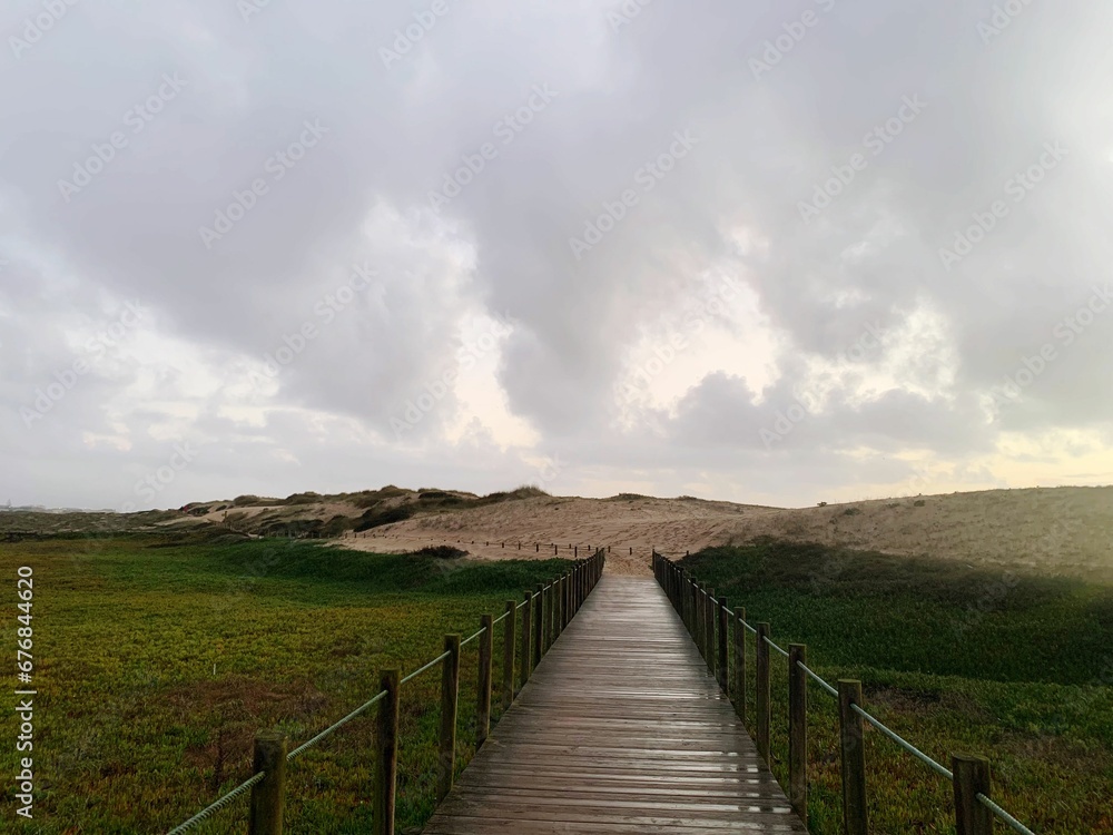 Scenic view of a trail in a green field near the ocean on Portugal coast