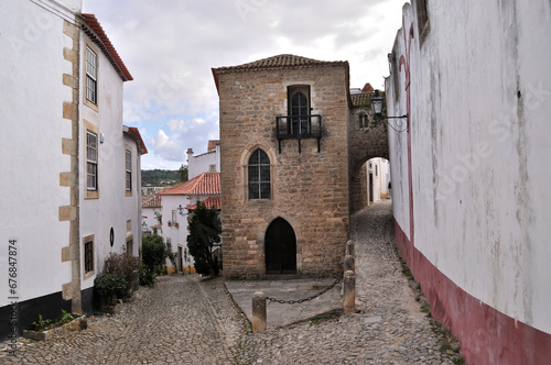 Cidade medieval de Óbidos em Portugal, bifurcação de uma rua com um edifício antigo ao meio