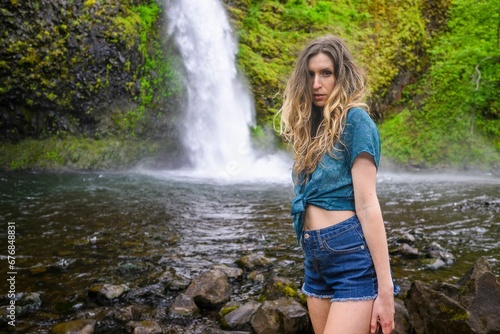 Attractive Caucasian woman standing against the Multnomah Falls in Oregon  Portland  USA