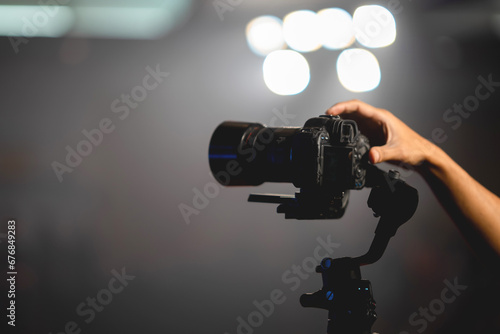 Photographer's hand holding a wedding video camera.