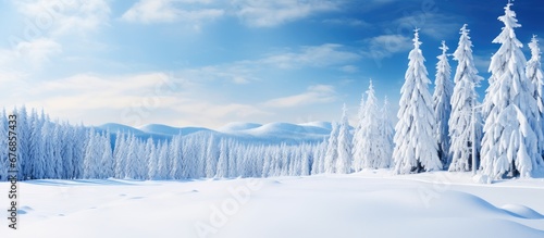 In the background of a picturesque winter landscape the sky is a vivid shade of blue as the snow covered forest and white dusted trees create a surreal scene perfect for a Christmas travel 