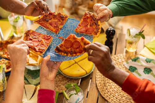 Detail photo of hands taking slices of pizza