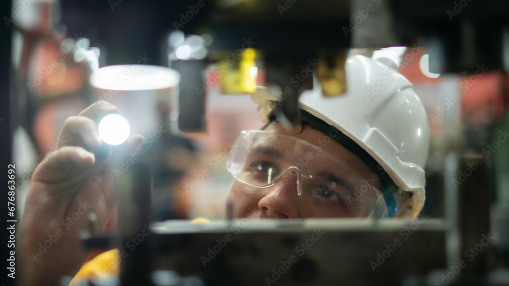 Male worker working with machinery, working at factory warehouse Employees working in industrial warehouses worker wearing a helmet