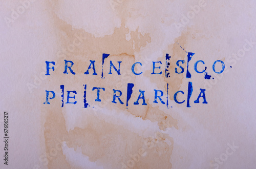 The name of the classic Italian poet Francesco Petrarca (1304 - 1374) is written in stamped letters in dark blue ink on textured aged paper. Good literature, reading list, favorite authors photo