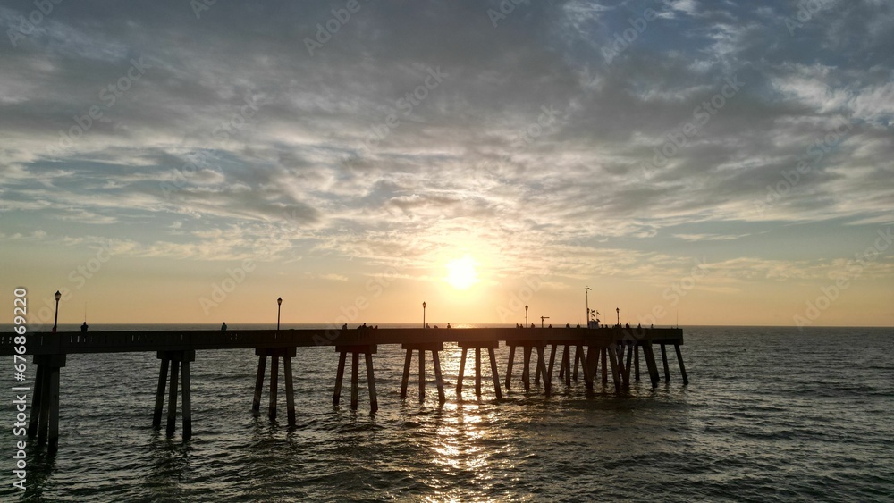 Beautiful sunset over a pier in the sea.