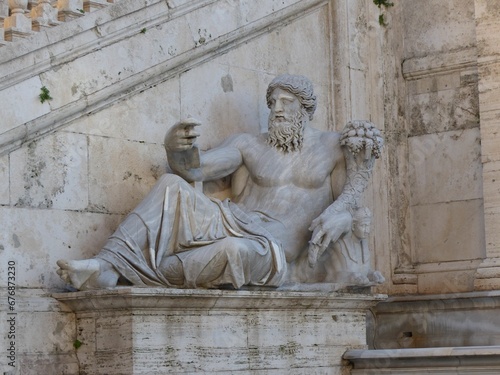 Ancient roman statue of the God Zeus by the Tiber river in Rome, Italy
