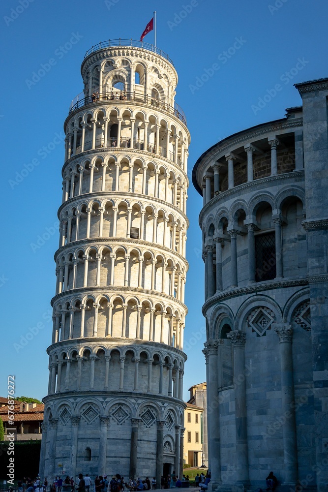 Group of people are walking around in front of the leaning tower of Pisa