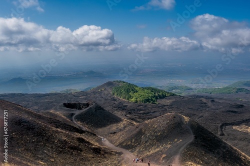 Aerial view of crateres Silvestri and Etna Volcano under blue cloudy sky with hikers photo