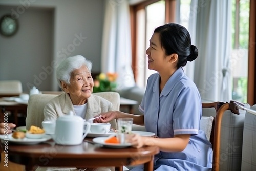 healthcare  an old woman eating breakfast at her house and at the living room table with a nurse. Assistance or dialogue  caretaker and discussion with a medical professional with an elderly woman