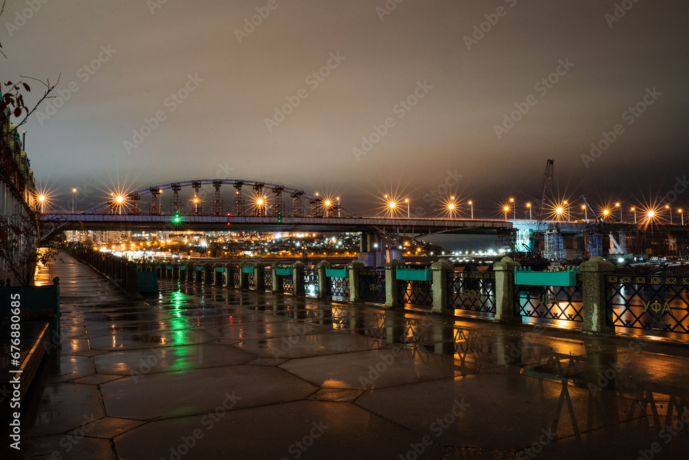 City promenade at night, bridge over the river, lanterns of the city at night, evening landscape, walking street.