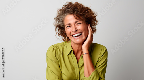 mujer adulta con un gesto de felicidad y sonriente vestida de verde, aislada en un fondo blanco  photo