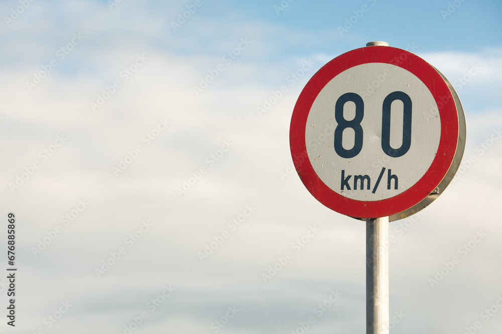 Travel concept. Information board on road. Speed limitation 80 km/h sign. Close up. Text space. Outdoor shot