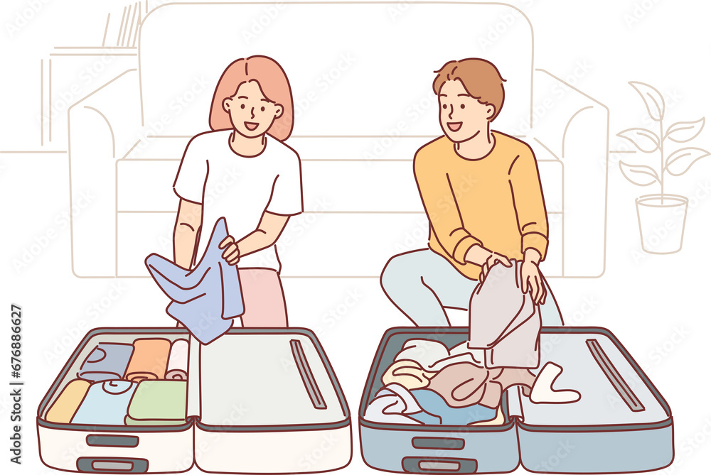 Man and woman are collecting baggage preparing to go on trip and kneeling near travel suitcases Man and woman are collecting baggage preparing to go on trip and kneeling near travel suitcases