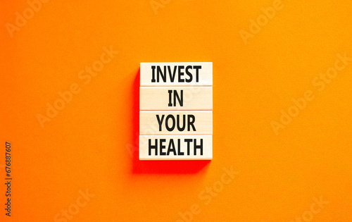 Invest in your health symbol. Concept word Invest in your health on beautiful wooden block. Beautiful orange table orange background. Invest in your health concept. Copy space.