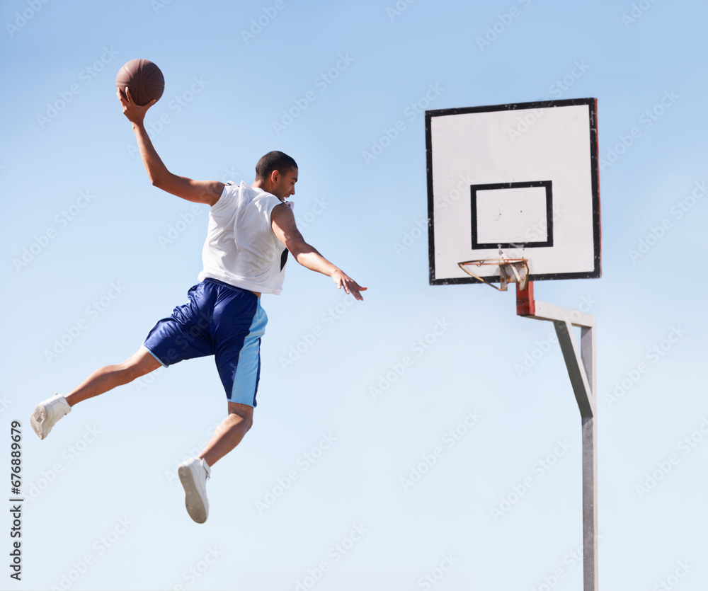 Fototapeta premium Man, basketball and dunk jump on outdoor court for scoring point, game challenge or athlete. Male person, hand and hoop strong for exercise fun or fitness training in summer, player for winner match