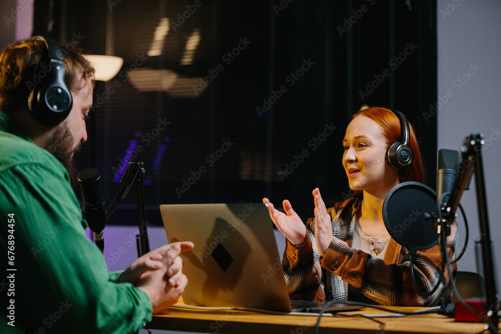 Man having conversation with woman in internet broadcast using professional microphone and audio mixer. Online radio station host recording podcast interviewing guest in late night talk show. Man having conversation with woman in internet broadcast using professional microphone and audio mixer. Online radio station host recording podcast interviewing guest in late night talk show.
