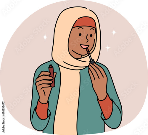 Smiling Arabic woman apply lipstick photo