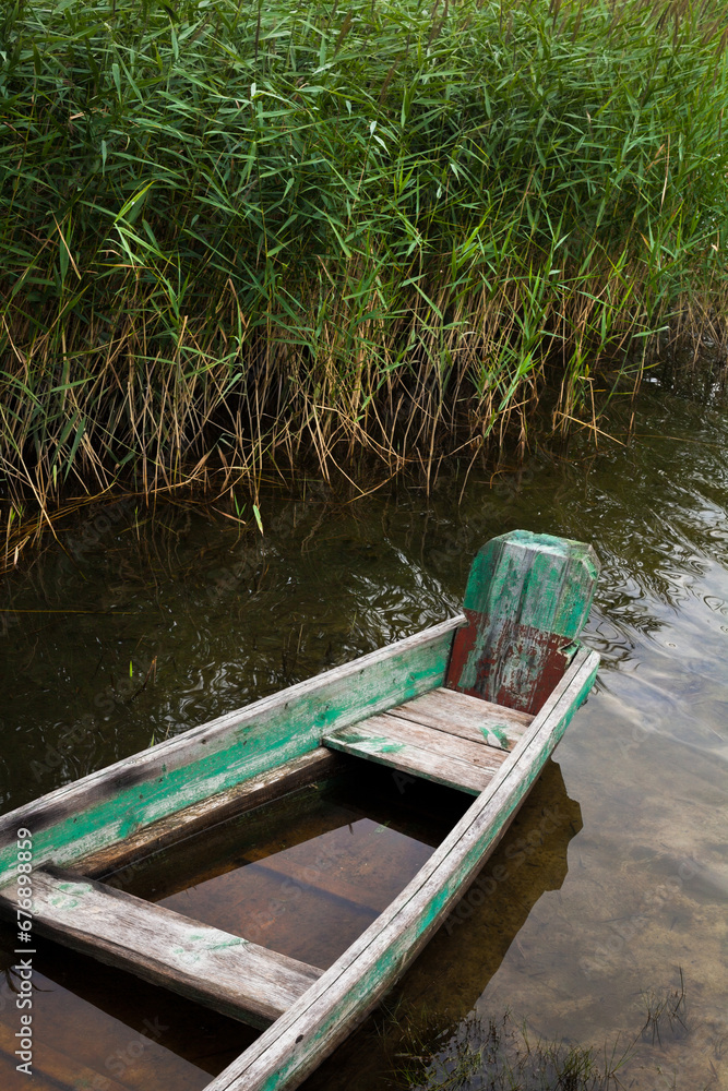 Old broken wooden boat filled with water Old broken wooden boat filled with water