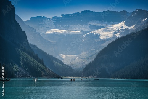 Beautiful shot of small boats in a lake surrounded by mountains in Banff and Jasper National Park