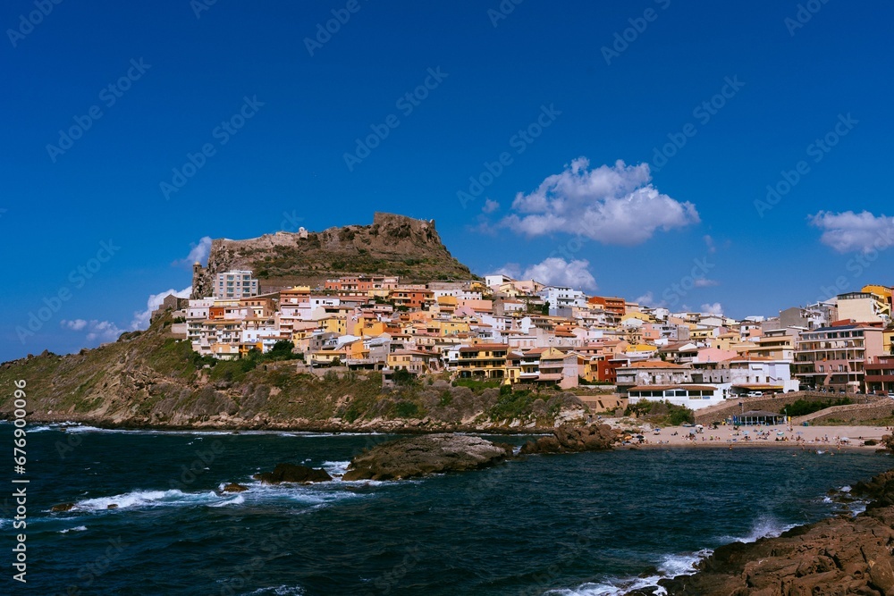 colorful buildings lining a coastal shoreline line near the ocean and cliffs