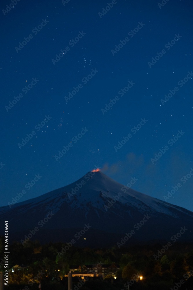 Volcano illuminated by the night sky, with stars visible in the background