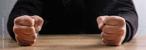 man fists on a wooden table photo