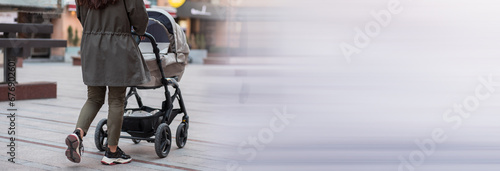 Girl walks in the street with a baby carriage photo
