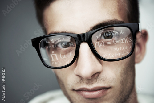 Portrait, glasses and formula with a man programmer closeup in studio on a gray background for support. Face, eyewear and software development with a young nerd or geek reading coding data or info photo