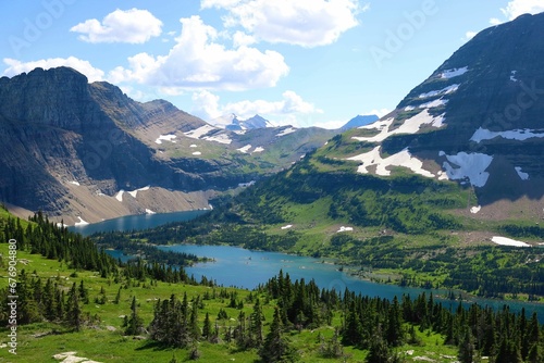 Glacier National Park with Hidden Lake flowing by the lush evergreen trees © Wirestock