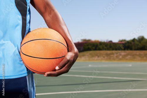 Basketball player, hand and court with ball outdoor in summer for sport, game and competition. Athlete, ready or start training, exercise or man closeup on playground for practice, workout or fitness