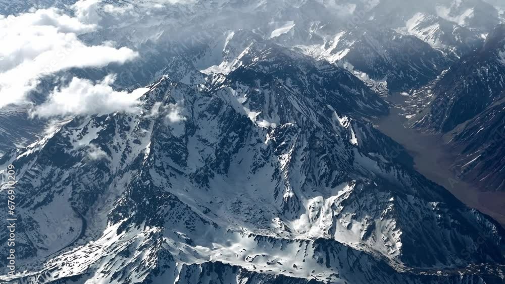 Vista da janela de avião comercial da Cordilheira dos Andes durante primavera. Muita neve e nuvens envolvendo as montanhas. Vista da janela de avião comercial da Cordilheira dos Andes durante primavera. Muita neve e nuvens envolvendo as montanhas.