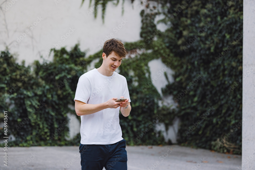 Young adult student using smart phone while going to school campus. Connected with friends everywhere, checking online bank, posting stories. Young adult student using smart phone while going to school campus. Connected with friends everywhere, checking online bank, posting stories.