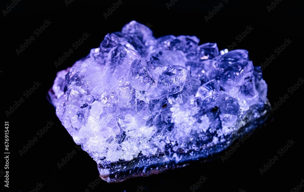 Closeup shot of a purple amethyst druse stone isolated on a black background