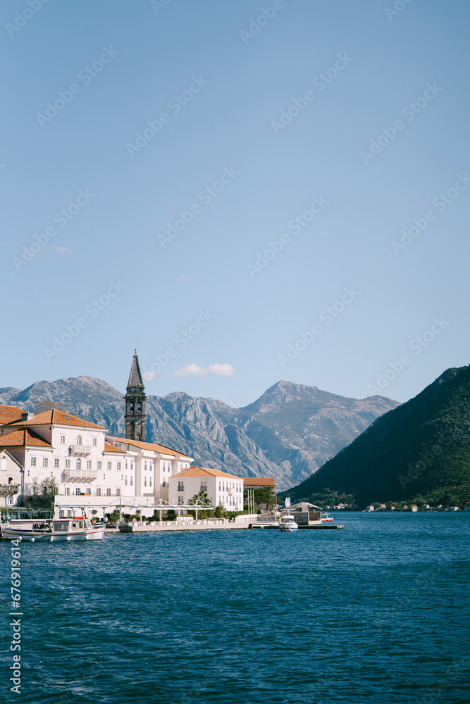 Ancient houses and the bell tower of the church on the Perast embankment. Montenegro