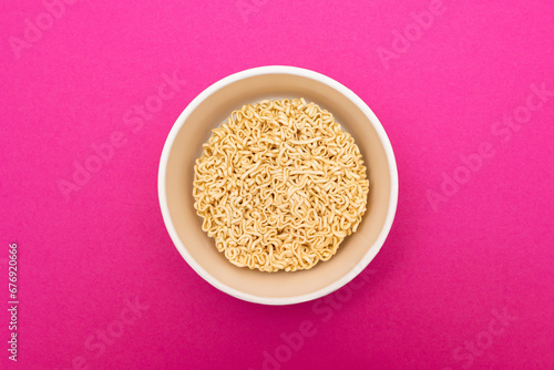 Opened Package with Uncooked Instant Noodles on Pink Background. Raw Pasta. Dry Asian Fast Food. Quick Lunch