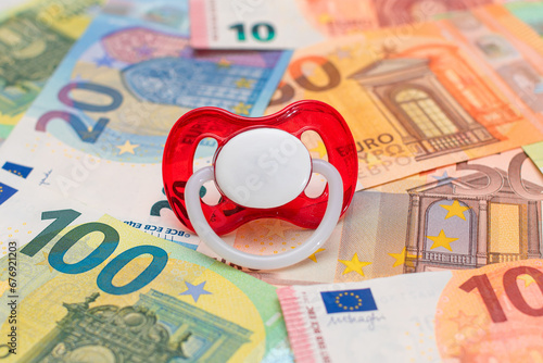 Childfree, Contraception and Birth Control Concept: Baby Pacifier on the Euro Banknotes. Having Children is Expensive and Unprofitable photo