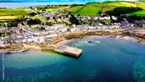 Aerial view of a blue seascape with residential houses on the coast in Scotland in sunny weather