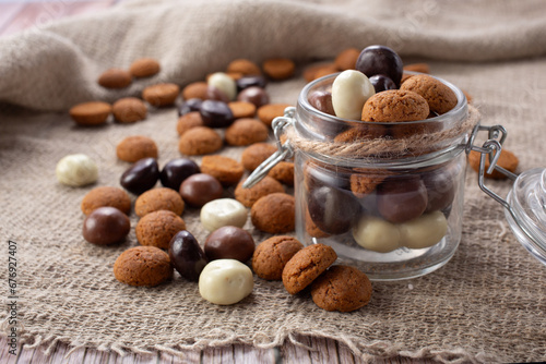 Pepernoten cookies in glass jar on sackcloth. Traditional sweets for St. Nicholas Day photo