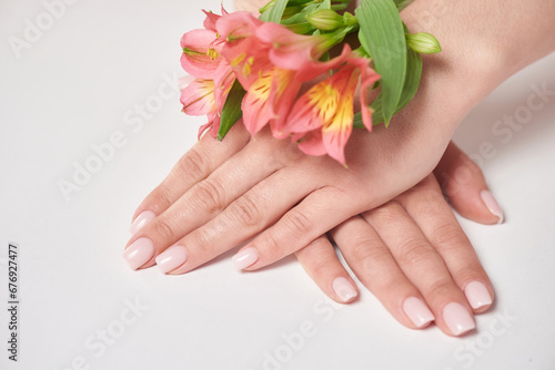 Gentle manicure of natural pink color and flower