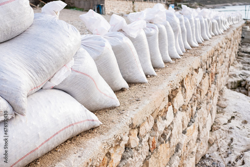 White sandbag bags are full with sand in wall formation and ready for defense.