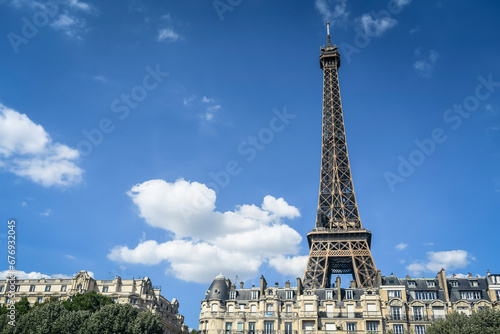 Fototapeta Naklejka Na Ścianę i Meble -  A Haussmann-style building (flat) with the Eiffel Tower (Tour Eiffel) in the background in Paris, France on July, 16, 2023