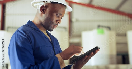 Black man, tablet and engineer at warehouse for maintenance, inspection or research on site. African male person, contractor or technician working on technology in online search or monitoring factory photo
