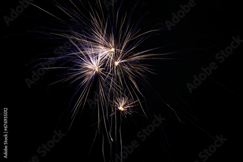 Gold and bluish fireworks isolated on a black background.