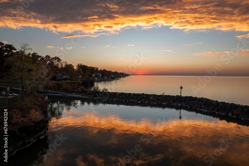 Landscape scene of Sunset sky over trees with reflection on Lake Erie in USA