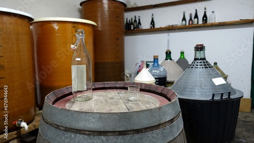 The interior of an old cellar for making red wine. A bottle and a glass are waiting for tasting.