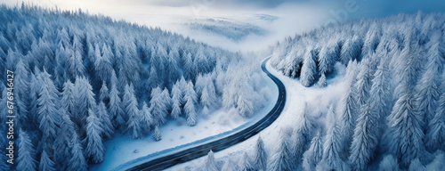 Winter snowy coniferous forest with winding road in mountain landscape. Blizzard has blown the roadway. Happy New Year or Christmas greeting card. Banner.